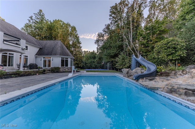 view of pool featuring a patio and a water slide