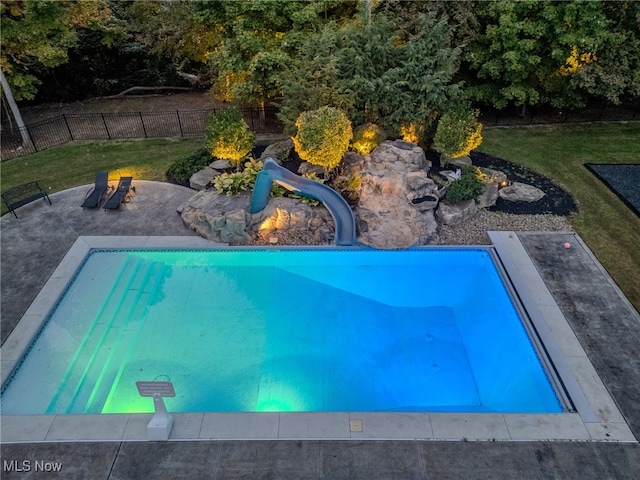 view of swimming pool with a lawn and a water slide