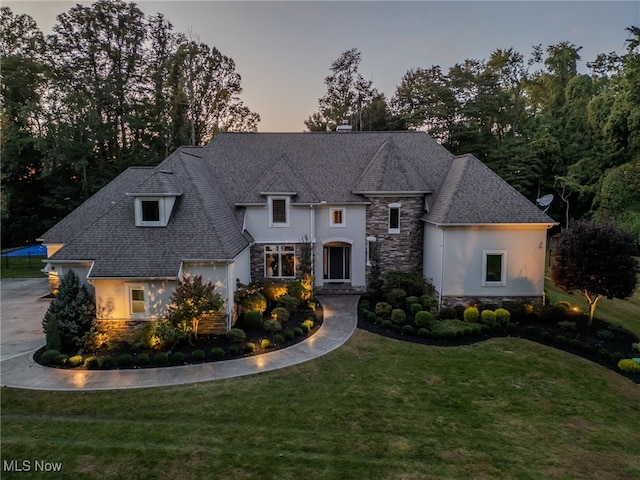 french country home featuring a lawn