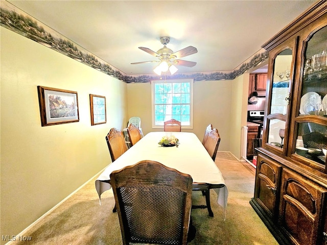 carpeted dining room with ceiling fan