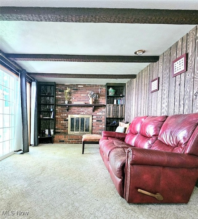 carpeted living room with beam ceiling, a textured ceiling, and a fireplace