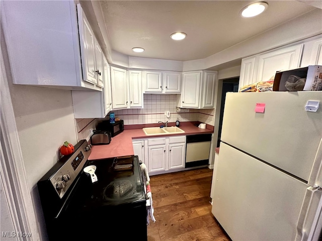 kitchen featuring white refrigerator, electric range, dishwashing machine, dark hardwood / wood-style flooring, and white cabinetry