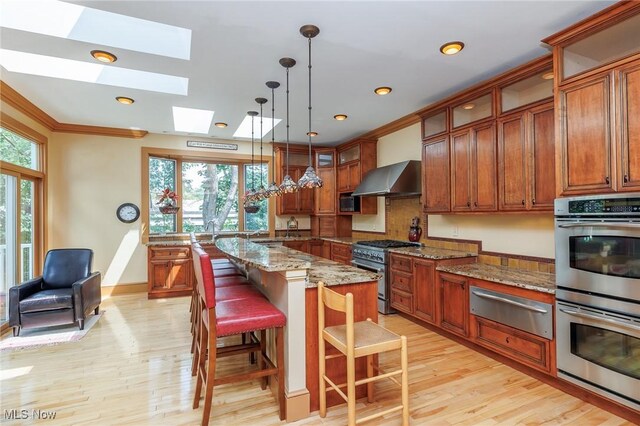 kitchen featuring a wealth of natural light, a skylight, appliances with stainless steel finishes, and a kitchen island