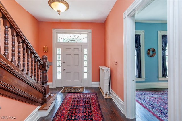 foyer entrance featuring dark hardwood / wood-style flooring and crown molding