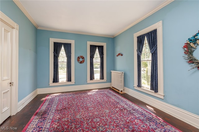 foyer featuring hardwood / wood-style flooring, crown molding, a wealth of natural light, and radiator