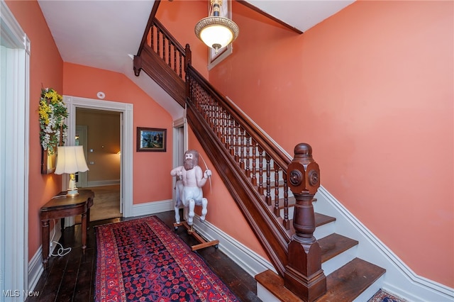 staircase featuring lofted ceiling and hardwood / wood-style floors