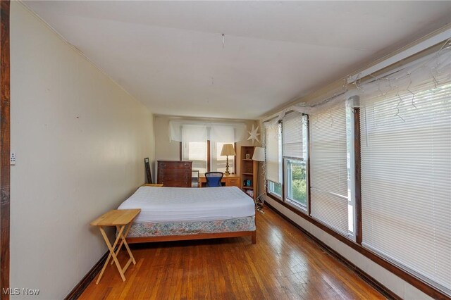 bedroom featuring hardwood / wood-style flooring and baseboard heating