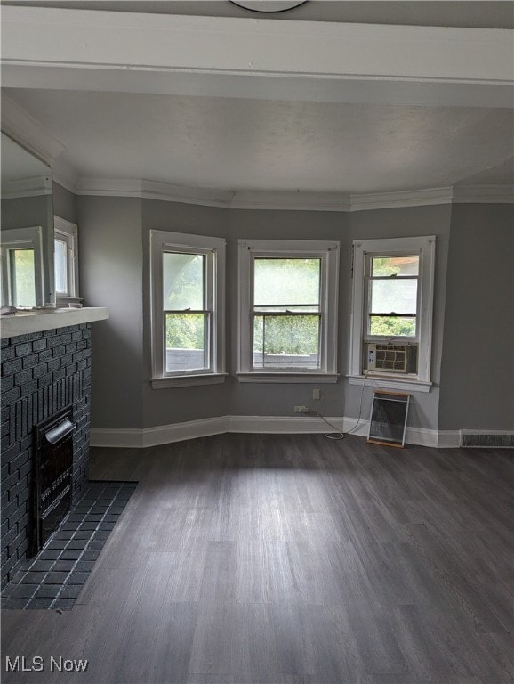 unfurnished living room with ornamental molding, cooling unit, dark wood-type flooring, and a fireplace