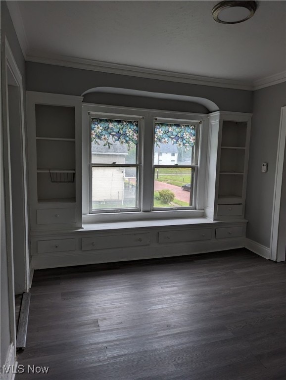 unfurnished room with ornamental molding and dark wood-type flooring