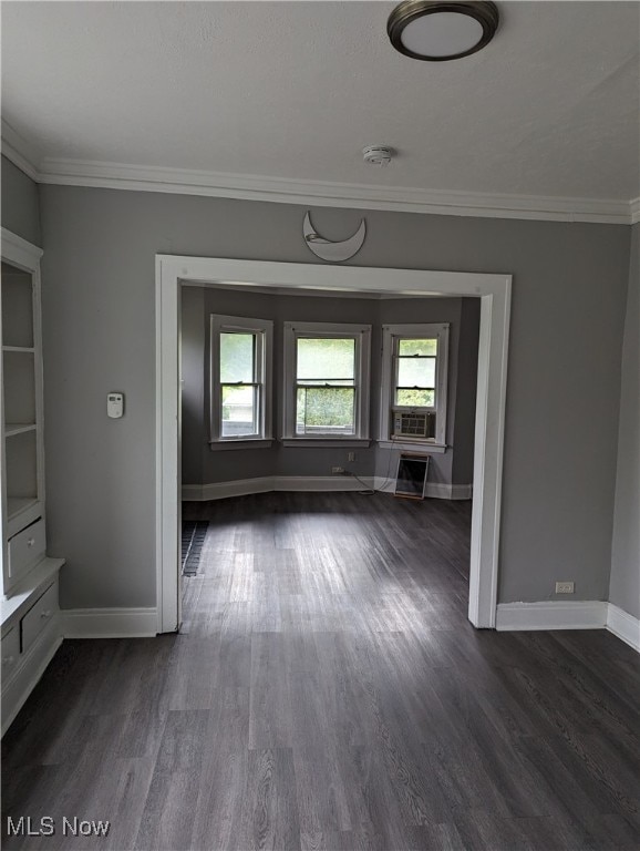 spare room with cooling unit, dark hardwood / wood-style floors, and crown molding