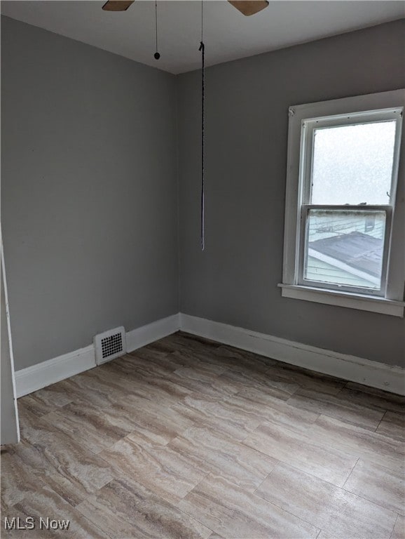 empty room with ceiling fan and light wood-type flooring