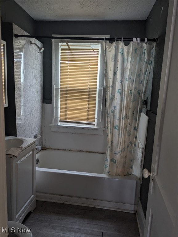 bathroom featuring shower / bath combination with curtain, vanity, a textured ceiling, and hardwood / wood-style flooring