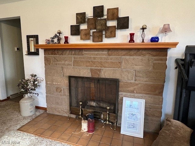 room details featuring tile patterned floors and a stone fireplace