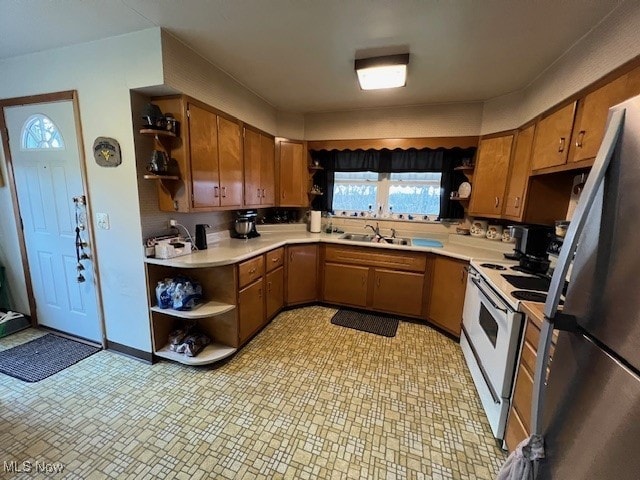 kitchen with sink, stainless steel fridge, white electric range, and light tile patterned floors