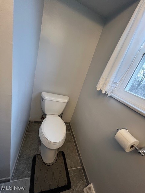 bathroom with toilet and tile patterned flooring