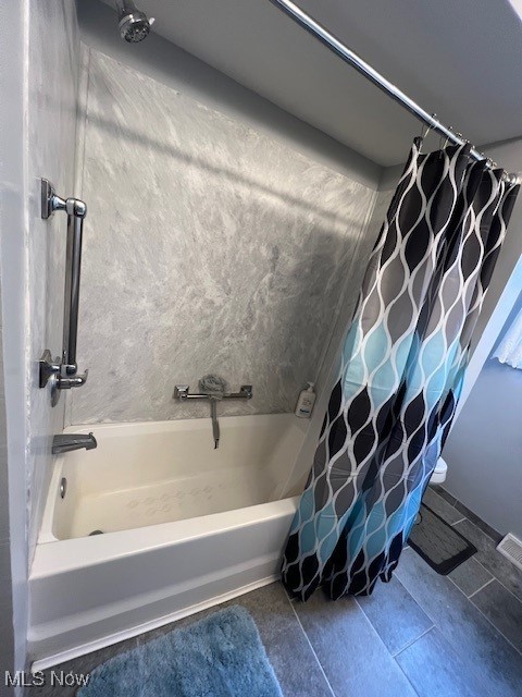 bathroom with tile patterned flooring and shower / bath combo