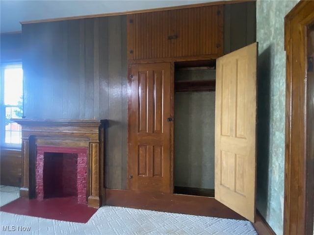 bedroom with wooden walls and a fireplace