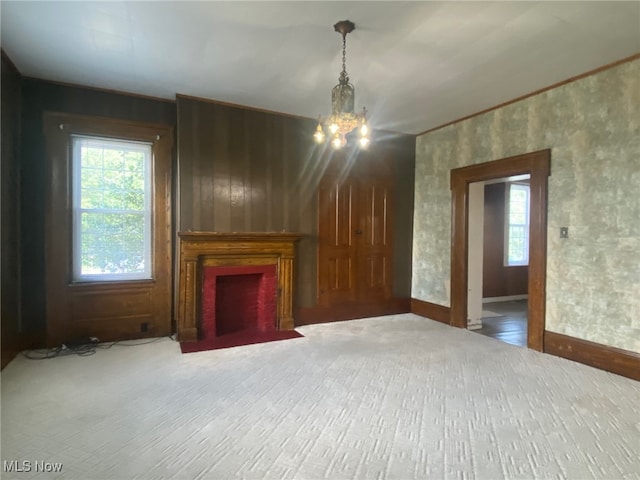 unfurnished living room with an inviting chandelier and hardwood / wood-style flooring