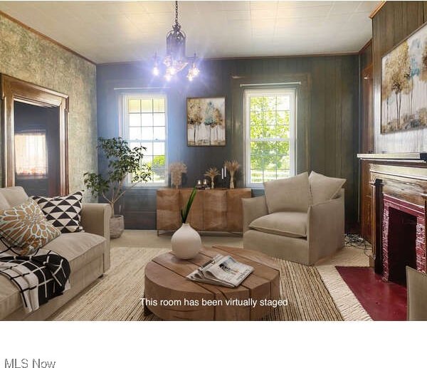 living room featuring wood walls, a chandelier, and a healthy amount of sunlight