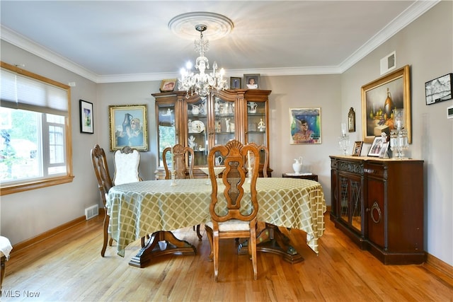 dining area featuring ornamental molding, an inviting chandelier, and wood-type flooring