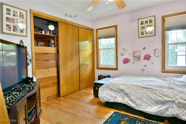 bedroom with a ceiling fan, a closet, and light wood finished floors