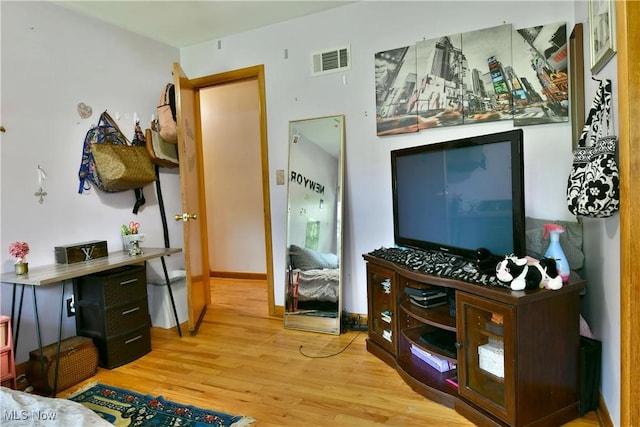 bedroom with wood finished floors, visible vents, and baseboards