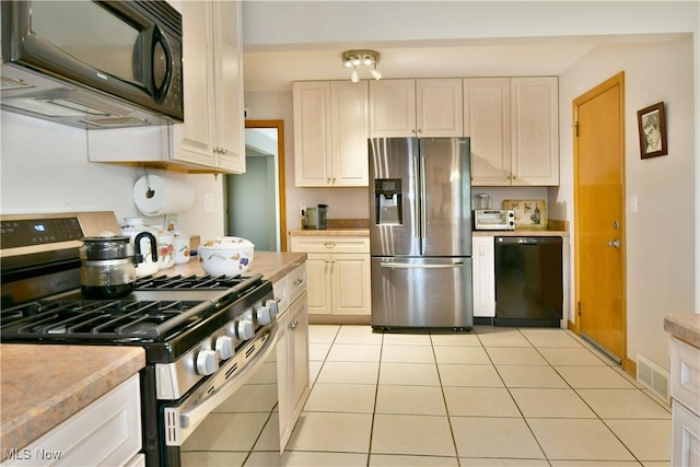 kitchen with light tile patterned floors, black appliances, light countertops, and visible vents