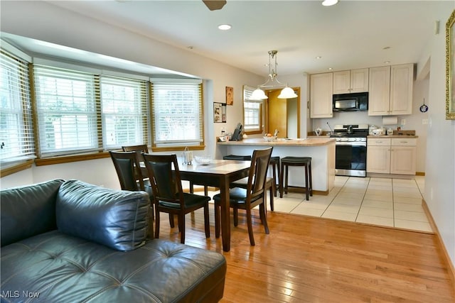 dining room featuring light wood-style flooring, baseboards, and recessed lighting