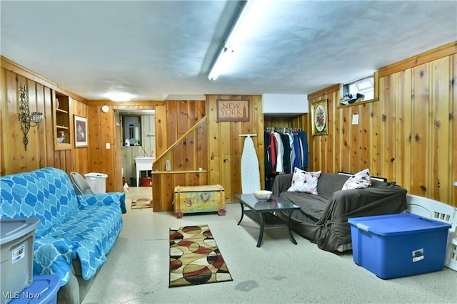 living room featuring stairs and wooden walls