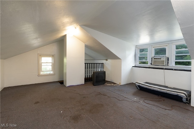 additional living space featuring carpet, vaulted ceiling, a textured ceiling, and cooling unit