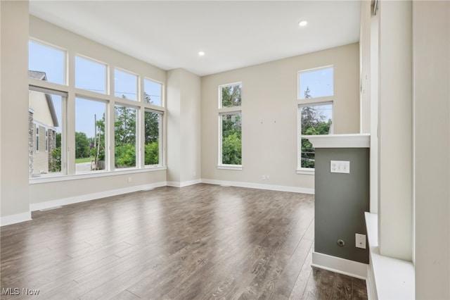 unfurnished living room with plenty of natural light and dark wood-type flooring