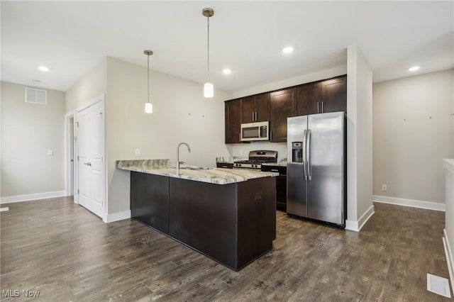 kitchen featuring stainless steel appliances, sink, dark hardwood / wood-style flooring, kitchen peninsula, and hanging light fixtures