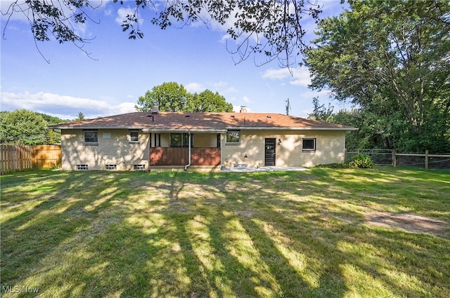 rear view of house featuring a lawn