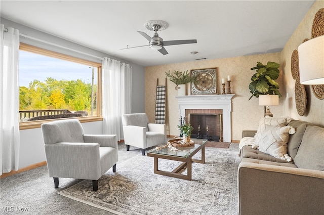 carpeted living room featuring a brick fireplace and ceiling fan