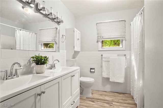 bathroom with tile walls, vanity, toilet, and hardwood / wood-style flooring