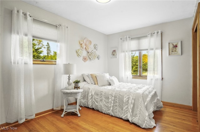 bedroom featuring multiple windows and hardwood / wood-style flooring