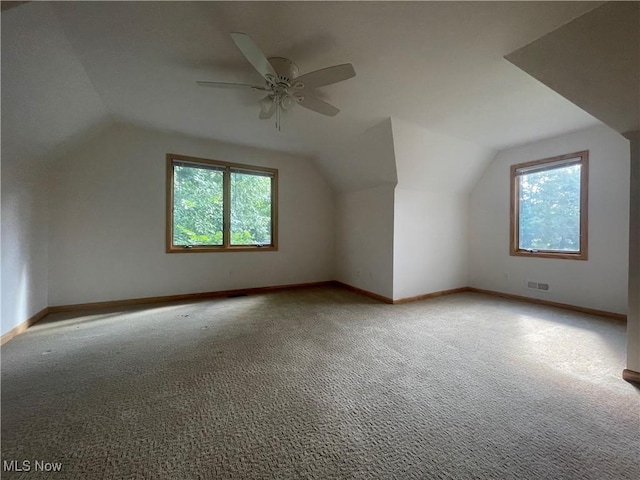 additional living space featuring ceiling fan, a wealth of natural light, and lofted ceiling