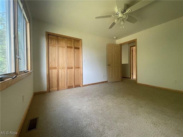 unfurnished bedroom with ceiling fan, a closet, and carpet floors