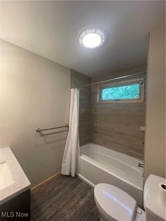 full bathroom featuring toilet, vanity, shower / bath combo with shower curtain, and hardwood / wood-style floors