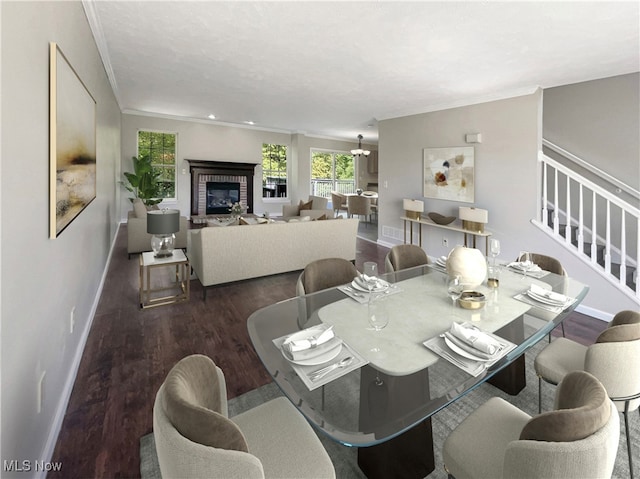 dining area featuring crown molding, hardwood / wood-style floors, and a brick fireplace