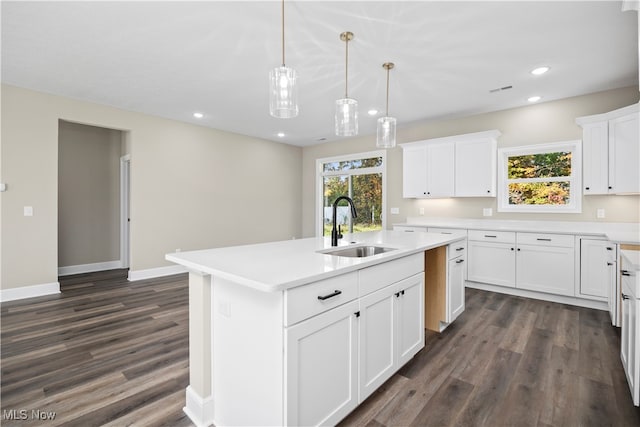 kitchen featuring a center island with sink, dark hardwood / wood-style floors, sink, and white cabinets