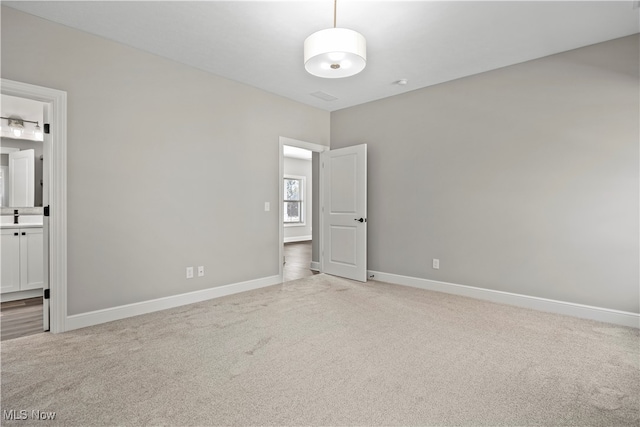 spare room with light carpet and sink