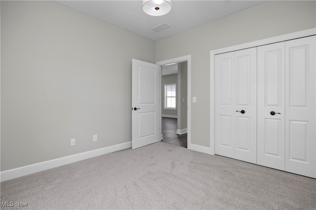 unfurnished bedroom featuring a closet and light carpet