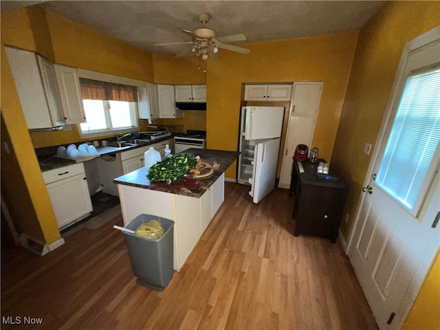 kitchen with ceiling fan, a kitchen island, gas range, white cabinetry, and light hardwood / wood-style floors