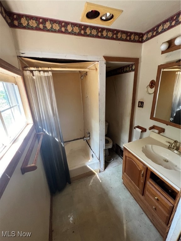 bathroom with concrete flooring, vanity, and toilet