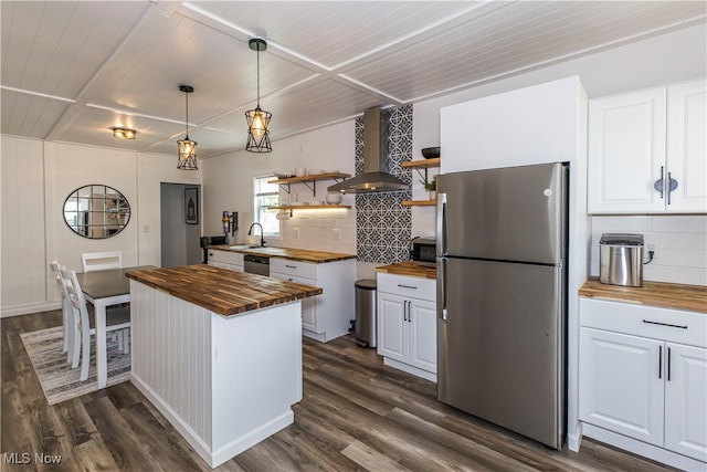 kitchen with appliances with stainless steel finishes, wood counters, dark wood-type flooring, and backsplash