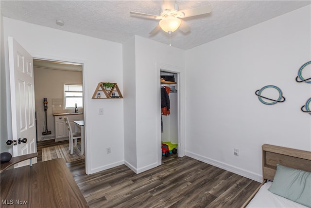 bedroom with dark hardwood / wood-style flooring, a closet, a textured ceiling, and ceiling fan