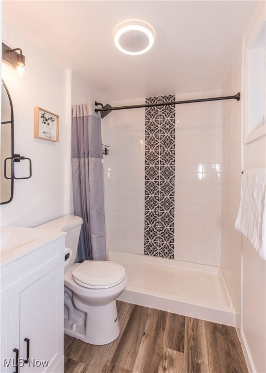 bathroom featuring a shower with curtain, vanity, hardwood / wood-style floors, and toilet