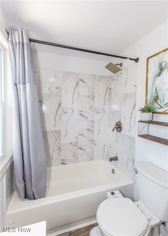 bathroom featuring shower / tub combo, wood-type flooring, toilet, and a healthy amount of sunlight