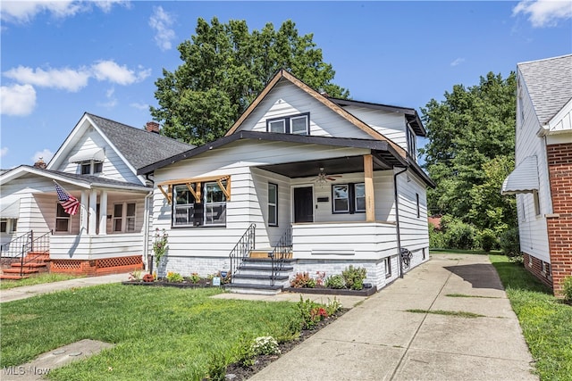 bungalow featuring ceiling fan, a porch, and a front lawn